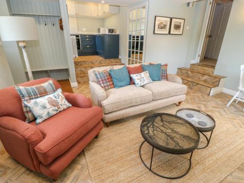 a living room with two chairs and a table at Overlea Cowshed in Highpeak Junction