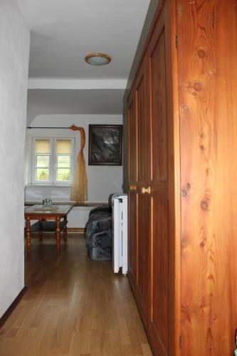 a living room with a wooden door and a table at Pension Pod Lipou in Loučovice