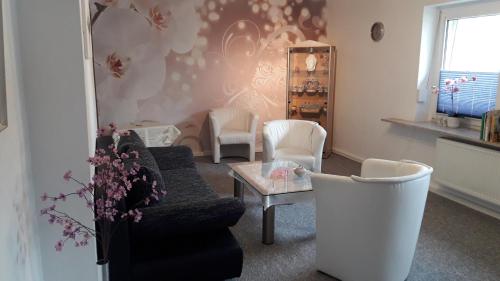 ヴィンターベルクにあるFerienwohnung Orchideeのリビングルーム(ソファ、テーブル、椅子付)