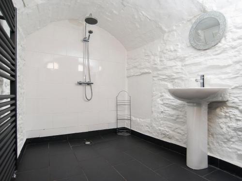 ein weißes Badezimmer mit Waschbecken und Dusche in der Unterkunft The Captain's Bank in Porthmadog