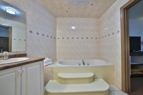 a bathroom with a tub and a toilet and a sink at King Hotel in Palmerston