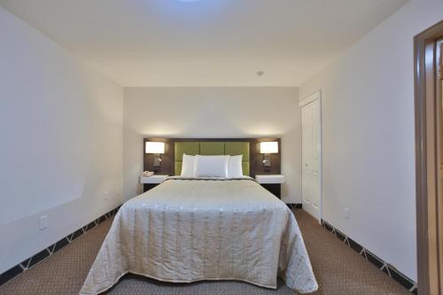a bedroom with a large bed with white sheets at King Hotel in Palmerston