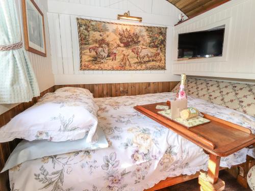 Dormitorio pequeño con cama y mesa en The Gypsy, en St Asaph