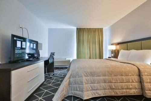 a hotel room with a bed and a flat screen tv at King Hotel in Palmerston