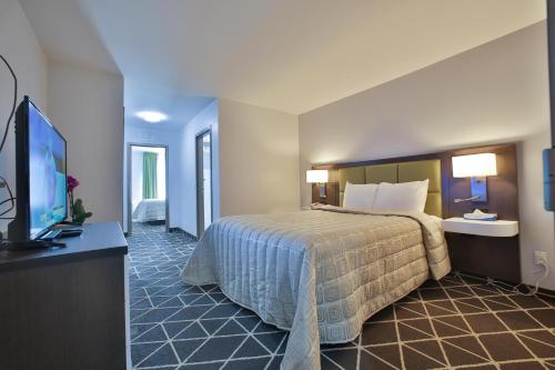 a hotel room with a bed and a flat screen tv at King Hotel in Palmerston