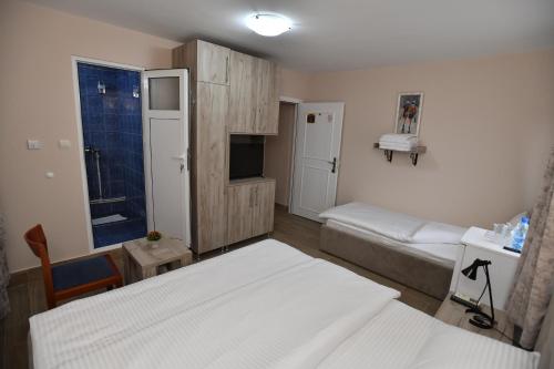 a small bedroom with two beds and a tv at Alijansa in Čačak