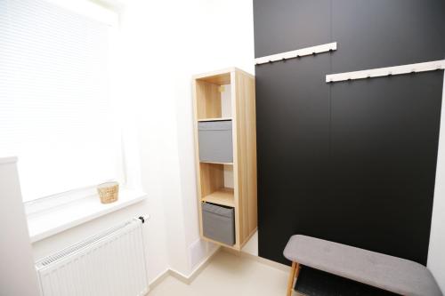 a room with a black door and a chair and a window at Šamorín - apartment in the center - free parking in Šamorín