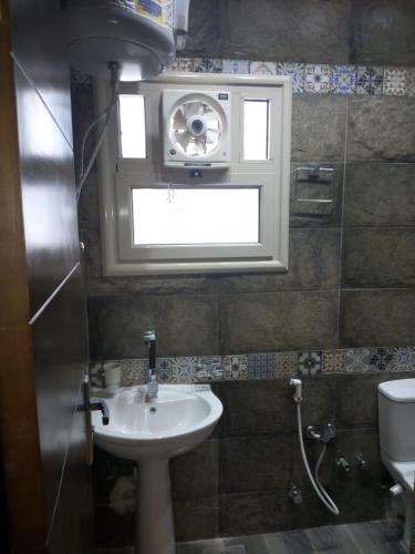 a bathroom with a sink and a window at Ramco For Furnished Apartments And Accommodation Compound Leila in Cairo