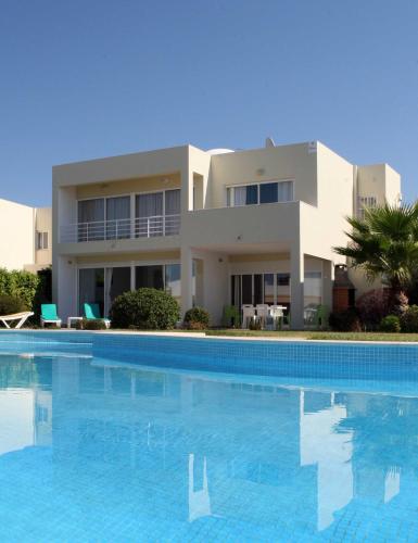 a large swimming pool in front of a house at Villas Oceano in Albufeira