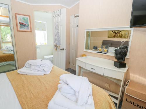 a bathroom with a mirror and a bed with towels at Ramblers Rest in Morpeth