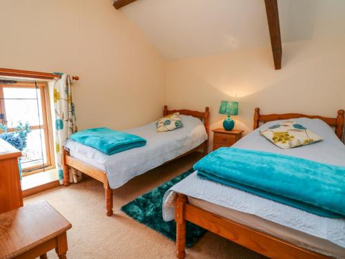 a bedroom with two beds and a window at The Shippon in Barnstaple
