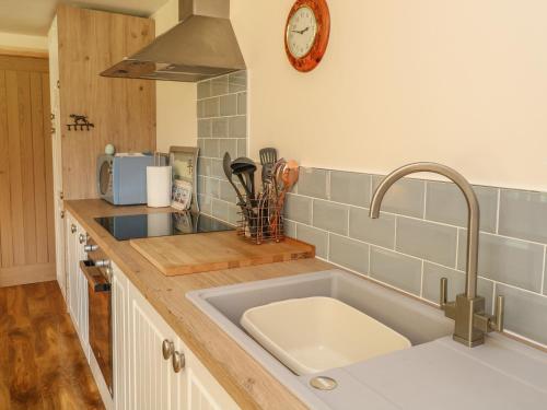 a kitchen with a sink and a clock on the wall at The Retreat in Brandon