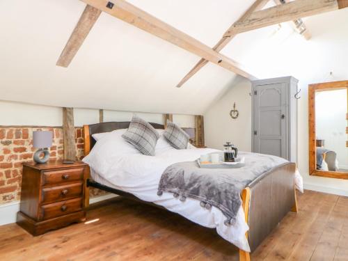 a bedroom with a bed and a dresser and a mirror at The Cart Shed in East Dereham