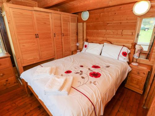 a bedroom with a bed with red roses on it at The Lodge in Milford Haven