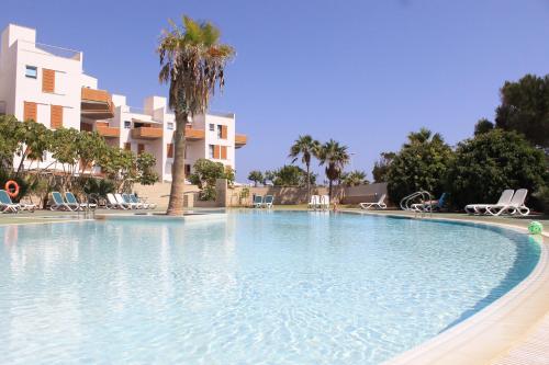 a large swimming pool in front of a building at Alquilaencanarias-Medano Los Martines beachfront A in El Médano