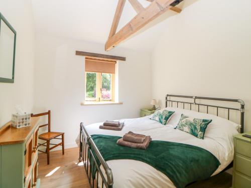 a bedroom with a bed and a desk and a window at The Granary in East Dereham