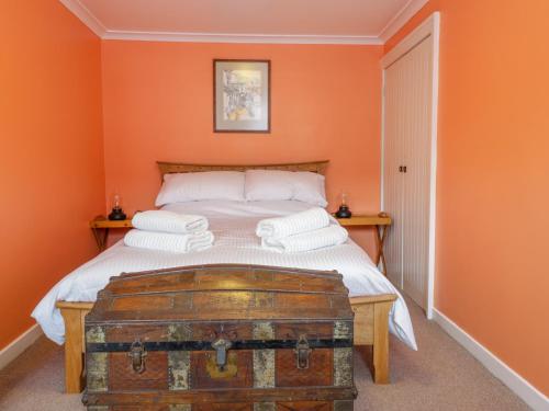 a bedroom with a bed with an old trunk at Shortbread Cottage in Cupar