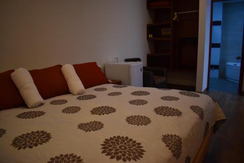 a bedroom with a bed with a comforter on it at Hotel Boutique Vendimia in Tarija