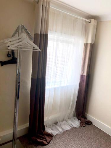 a bedroom with a window with curtains and a crib at AC Lounge 115 in Rochford