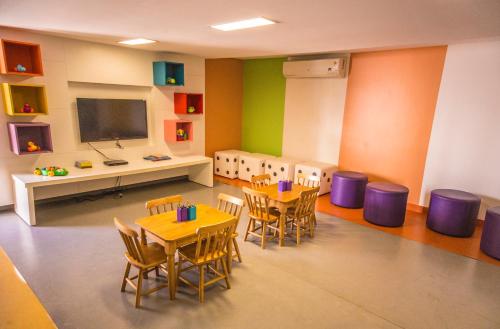a classroom with tables and chairs and a flat screen tv at Luxor Paulo Miranda Home Service in João Pessoa