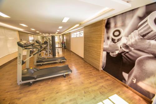 a gym with two tread machines and a wall mural at Luxor Paulo Miranda Home Service in João Pessoa