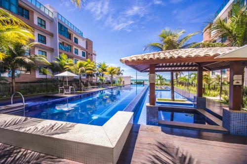 an infinity pool at a hotel with palm trees at Luxor Paulo Miranda Home Service in João Pessoa
