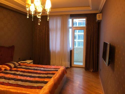 een slaapkamer met een bed en een groot raam bij For our friends Center 2 bedrooms in Baku