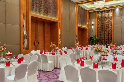 a banquet hall with white tables and white chairs at Movenpick Hotel Enshi in Enshi