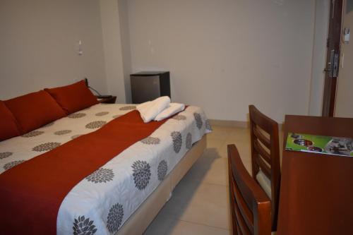 a bedroom with a bed with two towels on it at Hotel Boutique Vendimia in Tarija