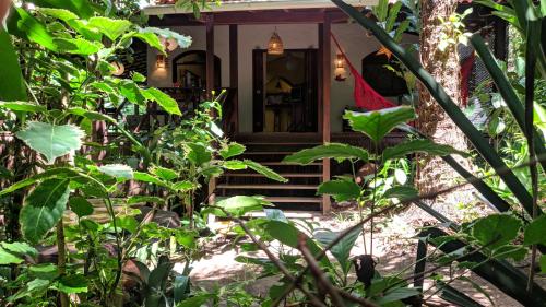 a front porch of a house with stairs and plants at Anjali in Ilha de Boipeba