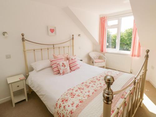 um quarto com uma cama grande e almofadas cor-de-rosa em Little Freestone em Kilgetty