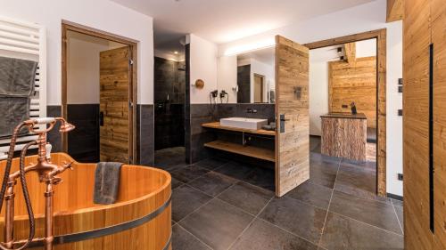 a bathroom with a tub and a sink at Tubla - Hof Maistatt in Dobbiaco