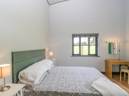 1 dormitorio con 1 cama grande y cabecero verde en Primrose, en Glastonbury