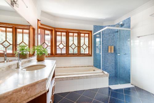 uma casa de banho com uma banheira, um lavatório e um chuveiro em Casa Paradisíaca na Lagoa da Conceição em Florianópolis