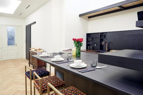 a kitchen with a large black counter with chairs and tables at Casa Vittoria Napoli - Santa Lucia in Naples