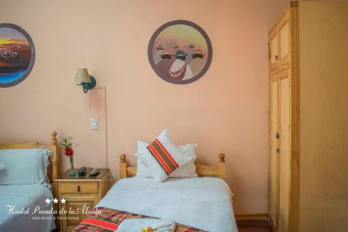 a bedroom with two beds and a picture on the wall at Hostal La Posada De La Abuela in La Paz