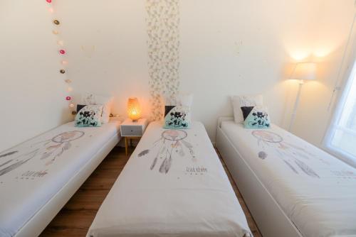 two twin beds in a room with a lamp at Disneyland Dream 3 - Charmant Appartement 7 pax in Serris