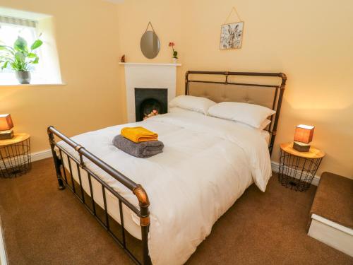 ein Schlafzimmer mit einem großen Bett und einem Kamin in der Unterkunft Glebe Cottage in Skipton