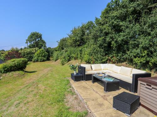 a couch sitting on a patio in a yard at Tan Yr Allt in Pwllheli