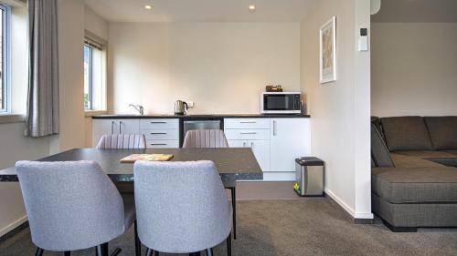 a kitchen with a dining room table and chairs at Autoline Queenstown Motel in Queenstown