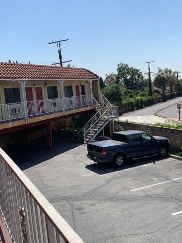 a black truck parked in a parking lot in front of a house at Budget Inn Motel in San Gabriel