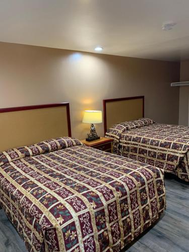 a hotel room with two beds and a lamp at Budget Inn Motel in San Gabriel