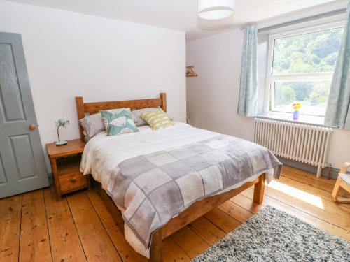 Un pat sau paturi într-o cameră la Cragside Cottage