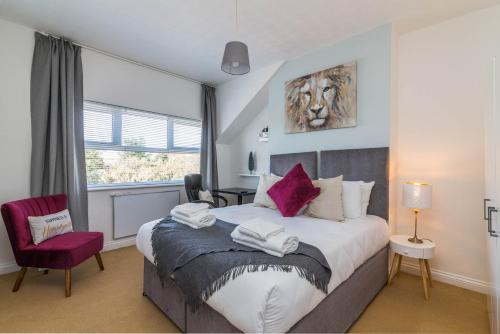 a bedroom with a large bed and a red chair at West Bridgford Classy 2bed Flat in Nottingham