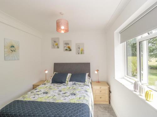 a bedroom with a bed and a window at Orchard Annexe in Lymington