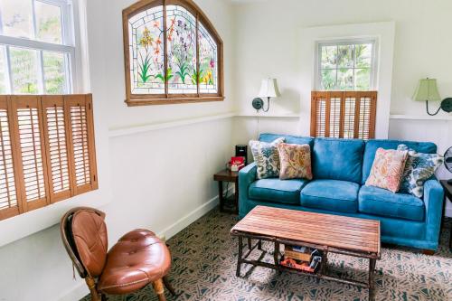 a living room with a blue couch and a table at Kilauea Lodge and Restaurant in Volcano