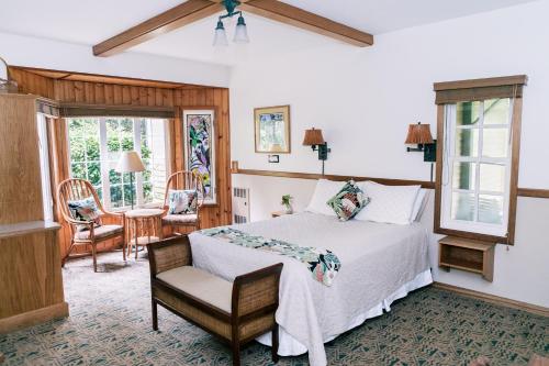 a bedroom with a bed and a chair and a table at Kilauea Lodge and Restaurant in Volcano