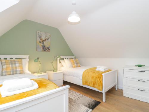a bedroom with two beds and a dresser at The Forge in Winscombe