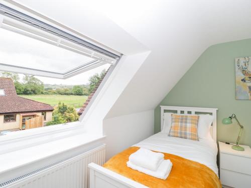 a bedroom with a bed and a large window at The Forge in Winscombe