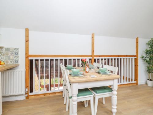 a dining room with a table and chairs and a balcony at The Forge in Winscombe